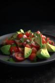 Avocado-Tomaten-Salsa auf einem Teller angerichtet.