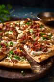 Flammkuchen-Fingerfood mit Schmand, Speck und Zwiebeln.