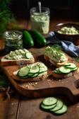 Frische Gurken-Hummus-Sandwiches auf einem Holzbrett