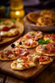 Party Snacks mit Pizzateig auf Holzbrett serviert